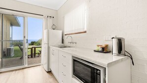Una cocina moderna con horno integrado, un lavamanos y una cafetera.