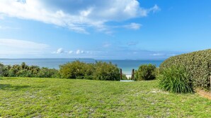 Un espacio cubierto de hierba con vista al mar y una isla distante.