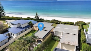 Zona residencial con casas, playa y un marcador de ubicación.