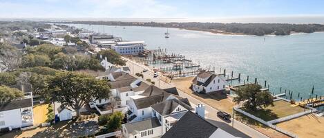 Un pueblo costero con casas blancas, un muelle y barcos en el agua.