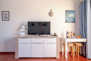 A modern living room with a flat-screen TV, a small sailboat model, a decorative vase, and a painting on the wall. - Beach House at D. Pedro Hotel w/ Pool & WIFI (Lagos)