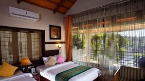 A hotel room with two beds, a window with curtains, an air conditioner, and a framed picture on the wall. - The Wave Wayanad Resort (Sulthan Bathery)