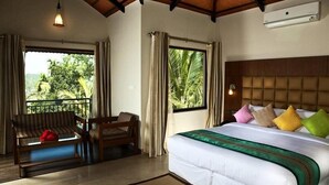 A hotel room with a bed, a sofa, and a window with curtains. - The Wave Wayanad Resort (Sulthan Bathery)