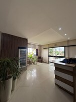 Una cocina moderna con refrigerador, pileta y plantas en macetas.