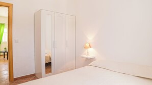 A bedroom with a bed, a wardrobe, and a bedside lamp. - Spyro Red Villa, Lagos, Algarve (Lagos)