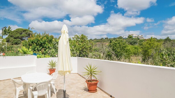 A rooftop terrace with a white table and chairs, a white umbrella, and potted plants. - Spyro Red Villa, Lagos, Algarve (Lagos)
