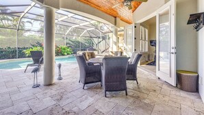 A covered patio area with wicker furniture, a ceiling fan, and a view of a swimming pool. - 3 Mi to Bonita Beach: Outdoor Oasis w/ Pool & Spa! (Bonita Springs)