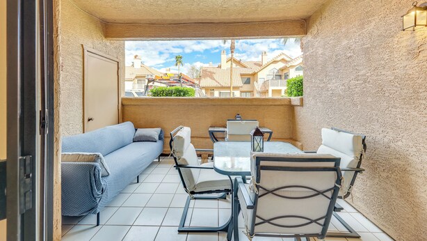 Un balcon avec un canapé, des chaises et une table.