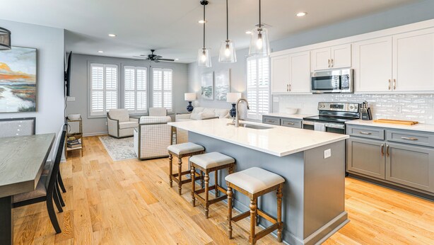 A modern kitchen with a large island, wooden stools, and stainless steel appliances. - Poolside Downtime, 4 Mi From Ole Miss (Oxford)