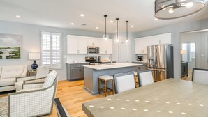 A modern kitchen with white cabinets, stainless steel appliances, and a central island with bar stools. - Poolside Downtime, 4 Mi From Ole Miss (Oxford)