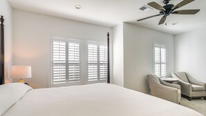 A hotel room with a large bed, two armchairs, a small table, and a ceiling fan. - Poolside Downtime, 4 Mi From Ole Miss (Oxford)