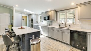A modern kitchen with a central island, stainless steel appliances, and a view of the outdoors. - Lake Moultrie Access: Moncks Corner Home w/ Dock (Moncks Corner)