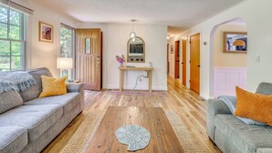 Un salon avec un canapé, une table basse et un couloir menant à une porte.