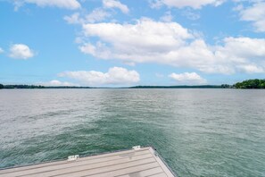Un lac paisible, avec une jetée en bois qui s’avance sur l’eau.