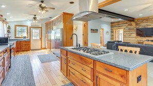 Une cuisine moderne avec des meubles en bois, un îlot central et une grande cuisinière.