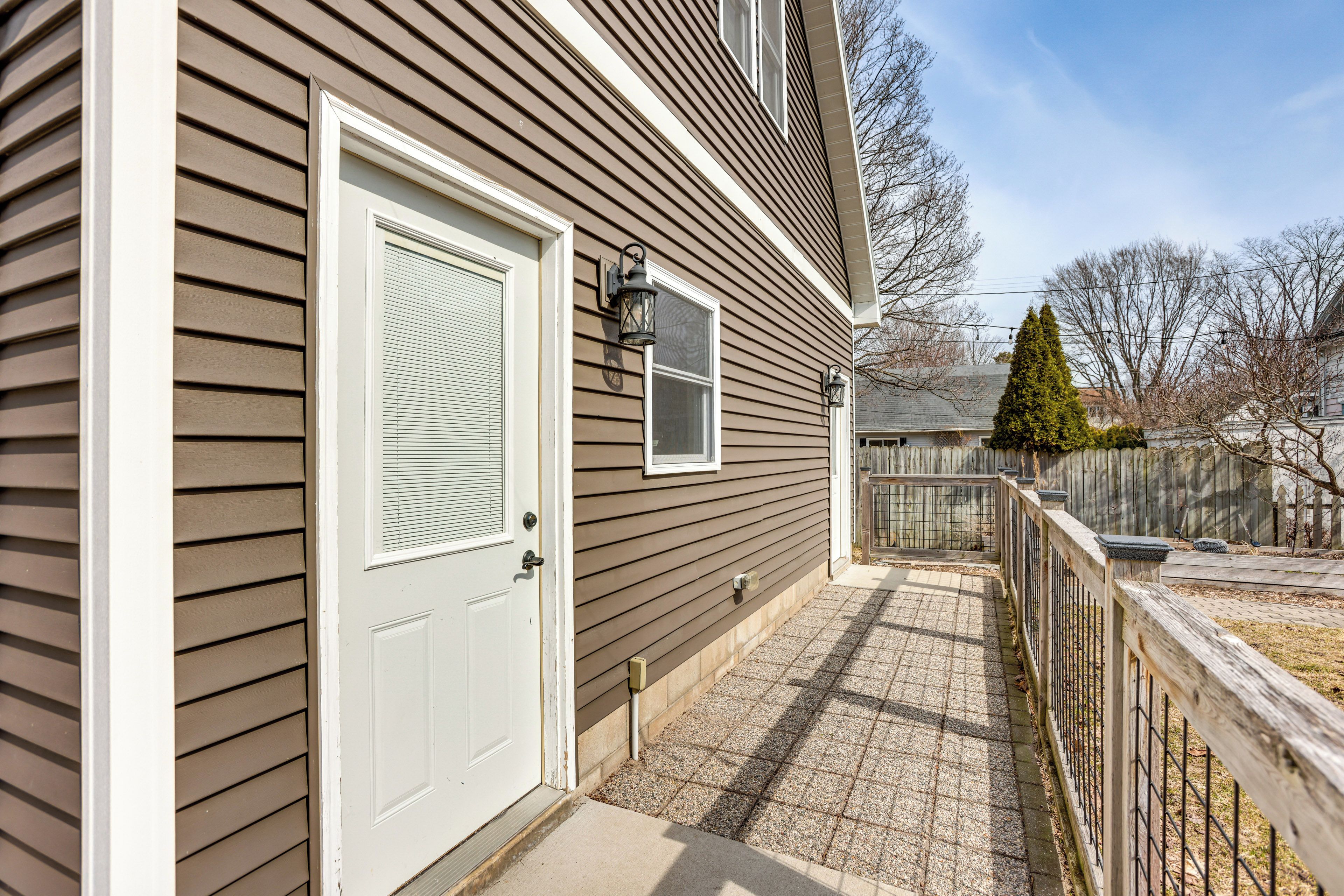 Une maison d’habitation avec une porte d’entrée, une petite fenêtre et une clôture en bois.