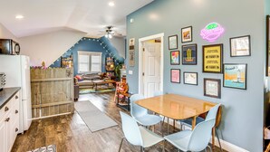 A dining area with a wooden table and light blue chairs, a kitchen with a white refrigerator, and a staircase leading to another level. - Close to Trails & Town! Artsy Apt in Frankfort (Frankfort)