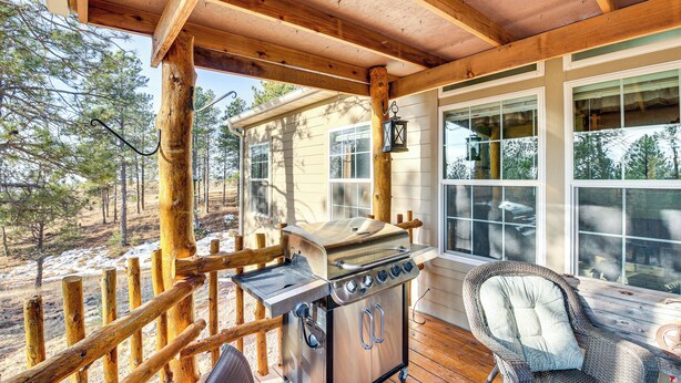 A covered outdoor area with a grill, a wicker chair, and a wooden deck. - 5 Mi to Town: Mtn-view Gem w/ Deck in Hot Springs (Hot Springs)