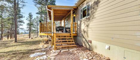 Une terrasse en bois menant à une maison, avec un chemin en pierre.