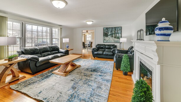 A spacious living room with a fireplace, leather sofas, and a large window. - 2 Mi to Suny Cortland: Home Near Hiking & Golf! (Cortland)