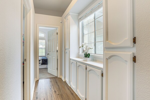 A hallway with white walls, a wooden floor, and a window with white curtains. - Family Home Near Folsom Lake in El Dorado Hills! (El Dorado Hills)
