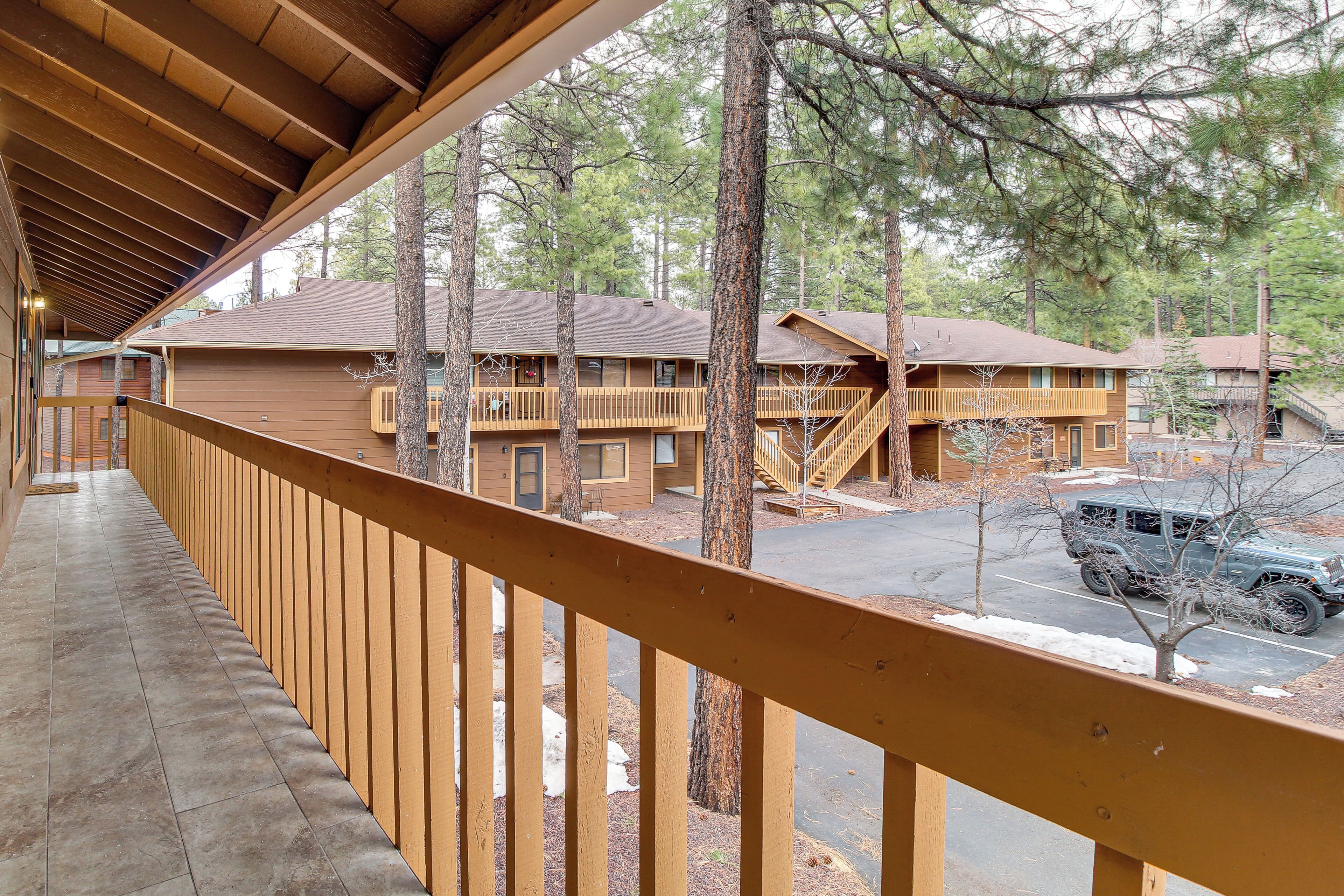A wooden building with multiple floors and balconies, surrounded by trees.