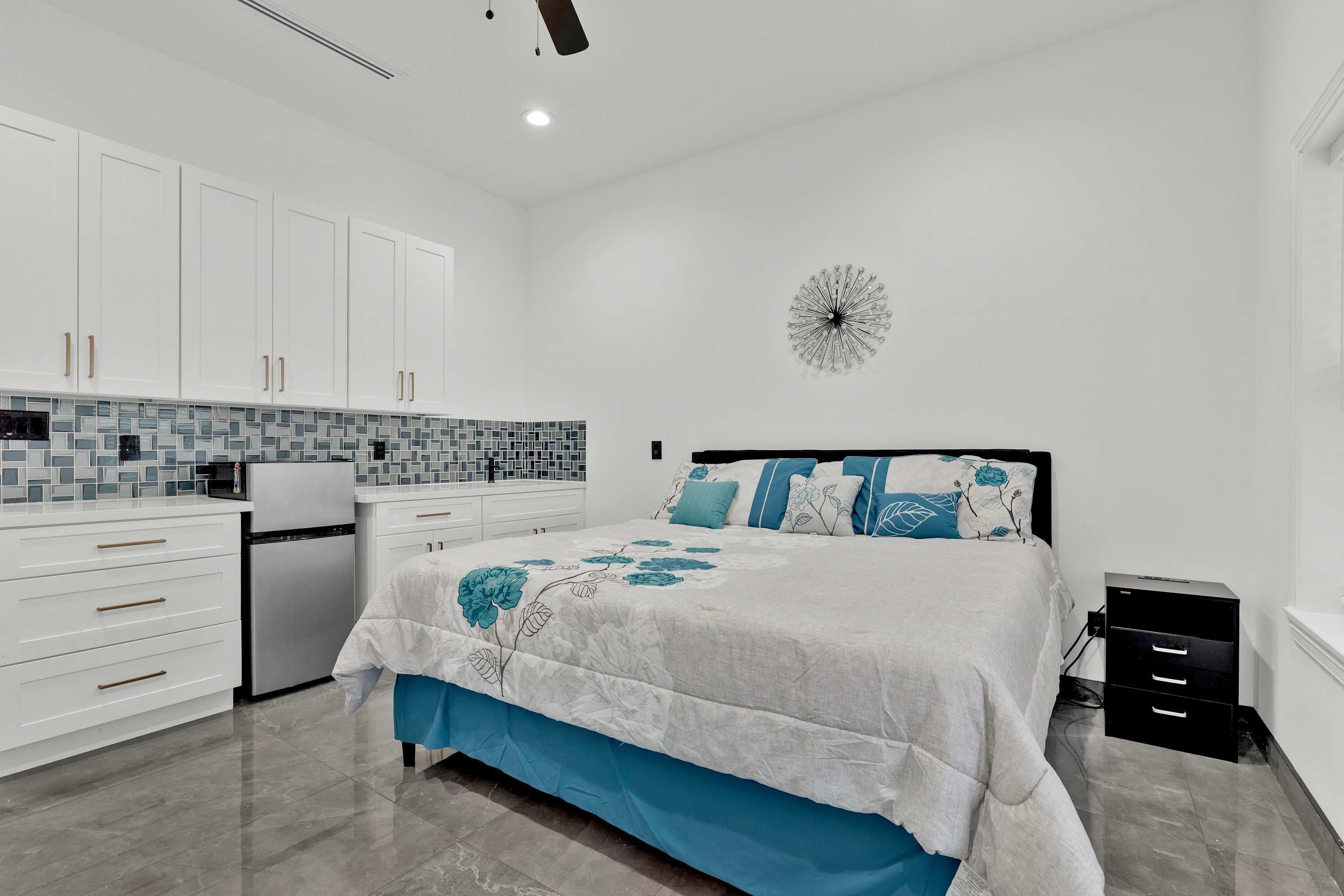 Un dormitorio moderno con cama, mesitas de noche y mesilla.