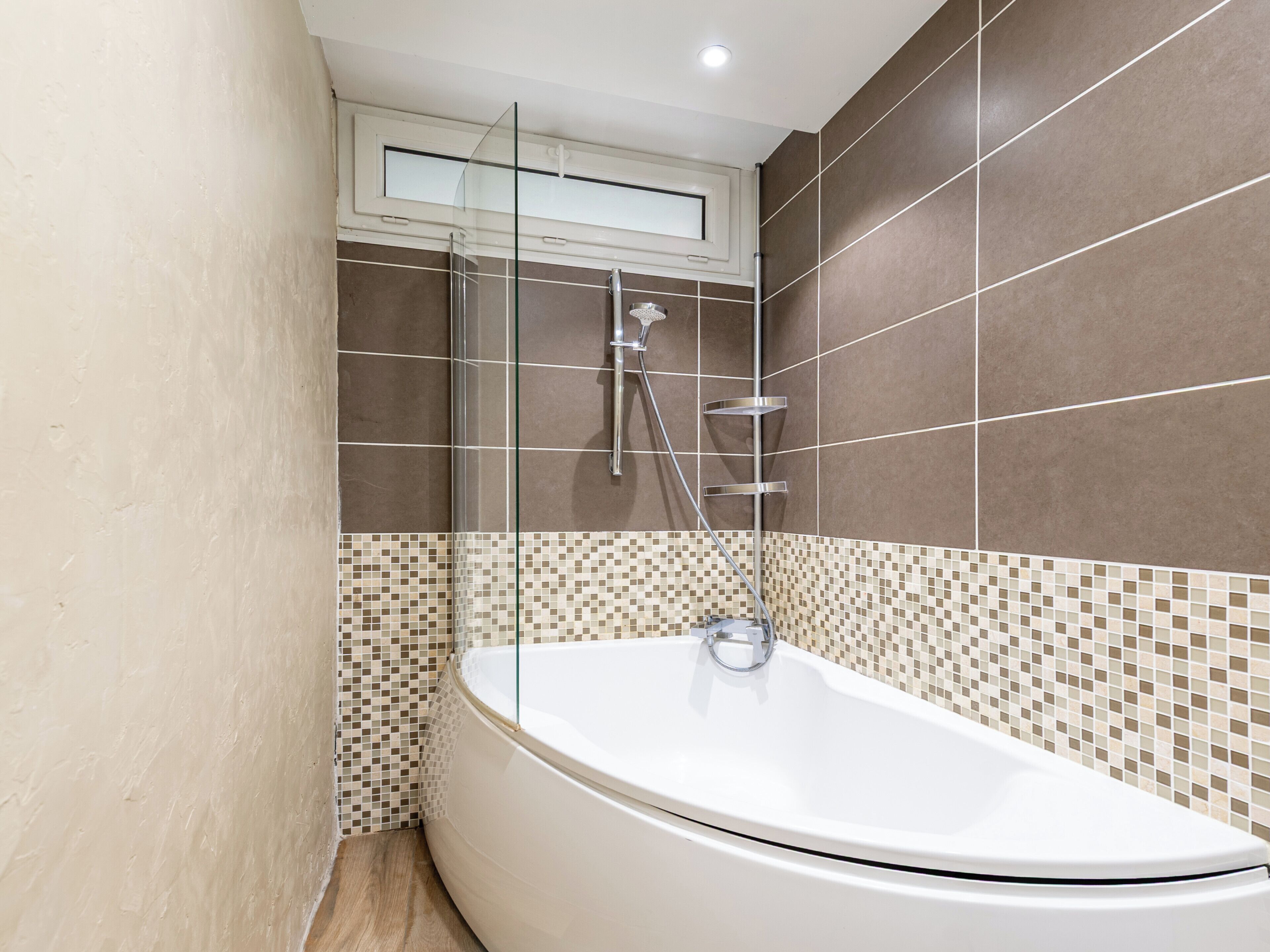A modern bathroom with a freestanding bathtub, a glass shower enclosure, and a tiled backsplash.