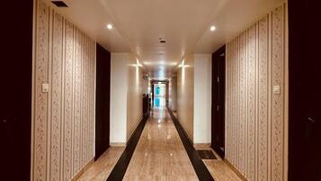 Un largo y estrecho pasillo con paredes decoradas y piso pulido.