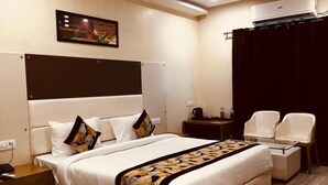 Una habitación de hotel moderna con una cama grande, un ventilador de techo, una mesita de noche, un escritorio y una silla.