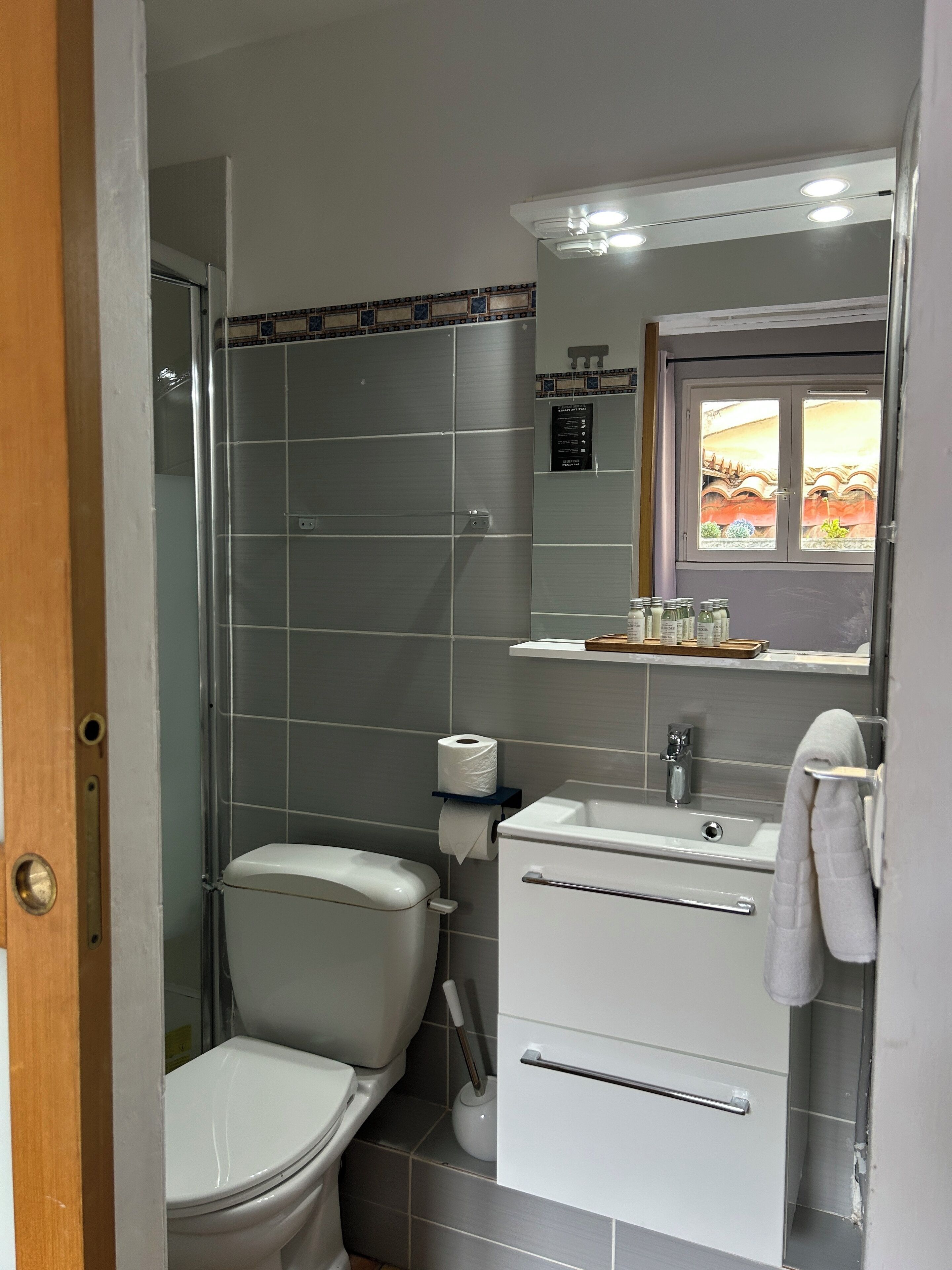 A bathroom with a toilet, sink, and shower.