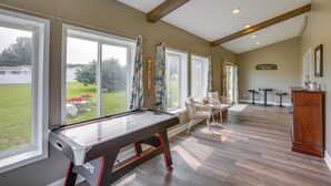 A pool table in a room with large windows, a wooden ceiling, and a view of a lawn. - Charming 5-bedroom Cadillac Retreat W/ Private Hot Tub Shared Basketball Court (Cadillac)