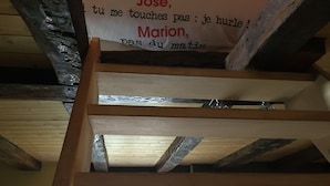 A wooden staircase with a sign in French. - DUPLEX UNDER THE SLOPES ON THE BANKS OF THE LOIRE (APT N°22) (Roanne)