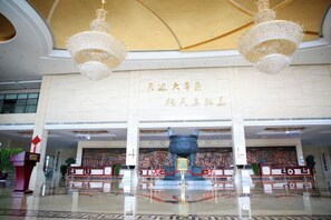 A spacious lobby with a high ceiling, chandeliers, and a large decorative urn. - Wulagai Guest House (East Ujimqin Banner)