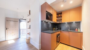 Eine moderne Küche mit Holzschränken, einer schwarzen Arbeitsplatte und einem eingebauten Backofen.