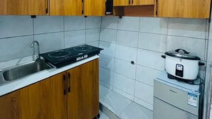 A kitchen with wooden cabinets, a sink, a stove, and a refrigerator.