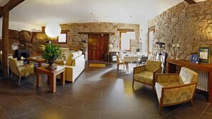 Eine geräumige Lobby mit Steinwänden, einem Kamin und gemütlichen Sitzbereichen.