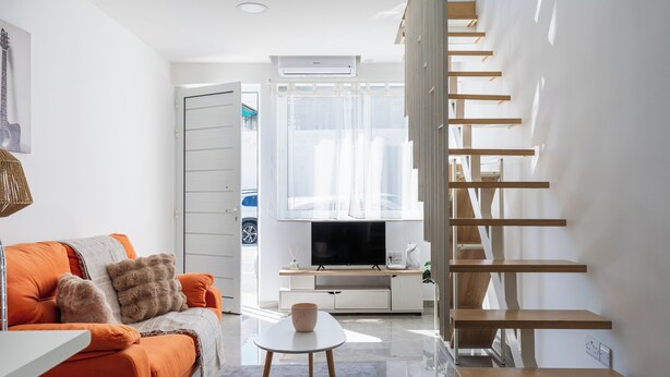A modern living room with a sofa, coffee table, and a TV. - Tangerine 1-Bedroom Apartment in Larnaca (Larnaca)