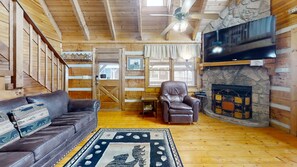 Relax in this inviting space with a leather sofa, armchair, and stone fireplace.