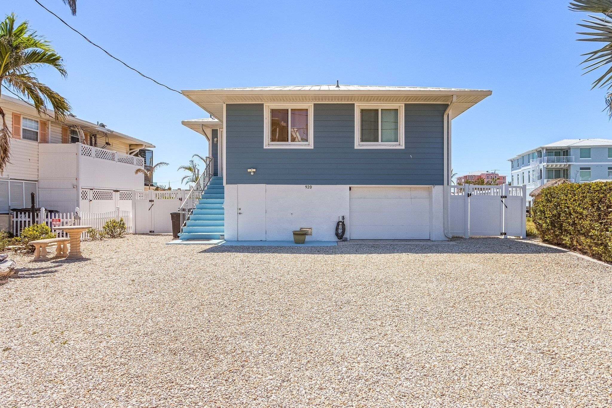A two-story house with a blue exterior and a white garage door.