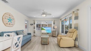 Una sala de estar con un sofá, un sillón reclinable, una mesa de centro y un televisor.