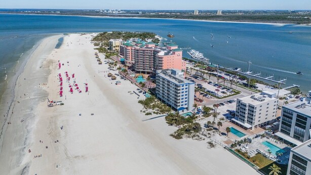 A coastal hotel with multiple buildings, a beach, and a marina. - Beach Villas 706 Top-floor Condo W/ Gulf Views, Pool 2 Bedroom Condo (Fort Myers Beach)