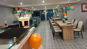 Un restaurante con cabinas y mesas, decorado con globos.