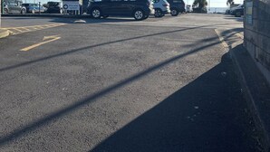 A parking lot with several cars and a sign indicating a one-way system. - Boat Accommodation Ltd (Torquay)