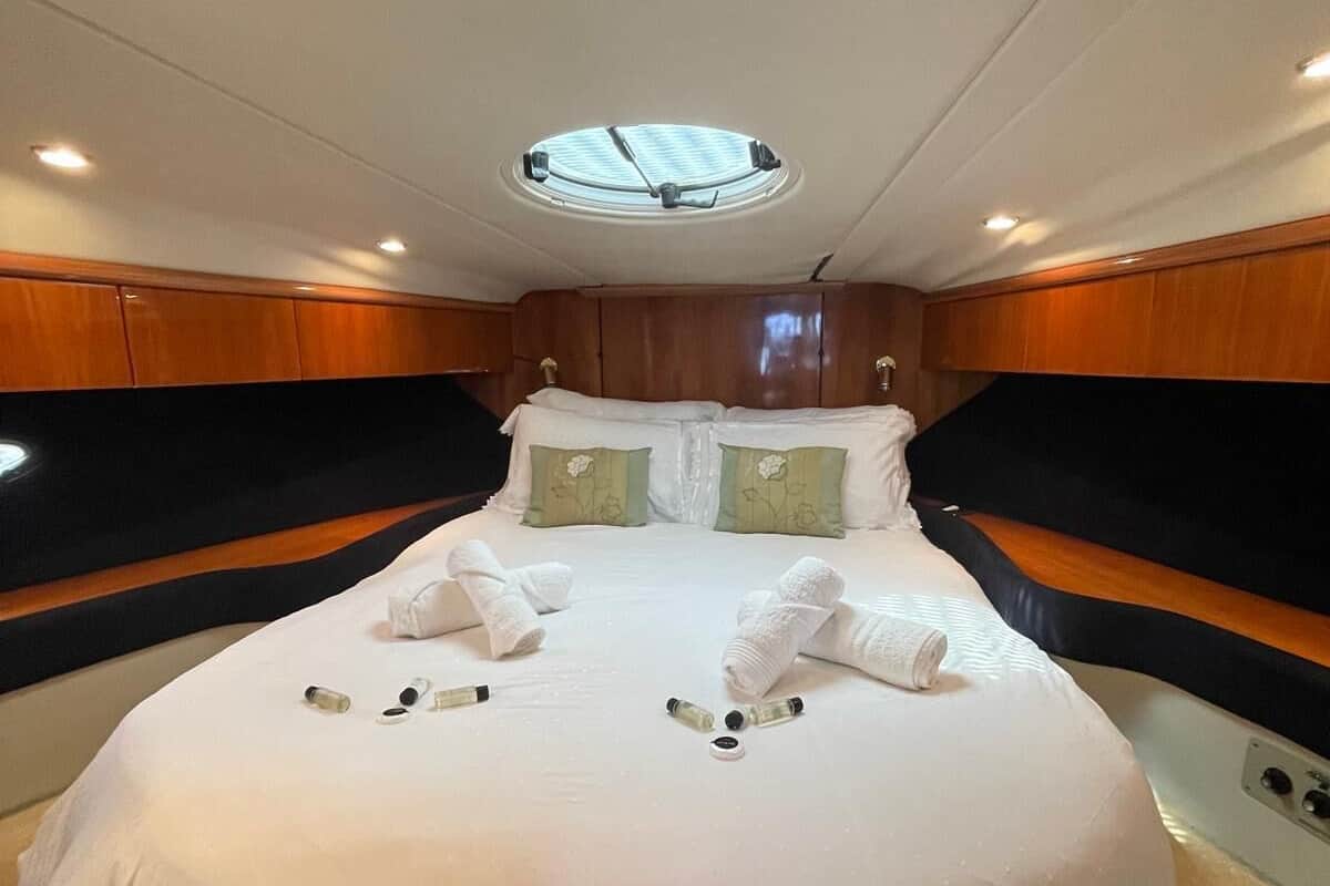 A spacious, well-lit bedroom with a large bed, wooden paneling, and a skylight.