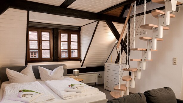 Un dormitorio con una cama, un aparador, una ventana y un rascador para gatos.