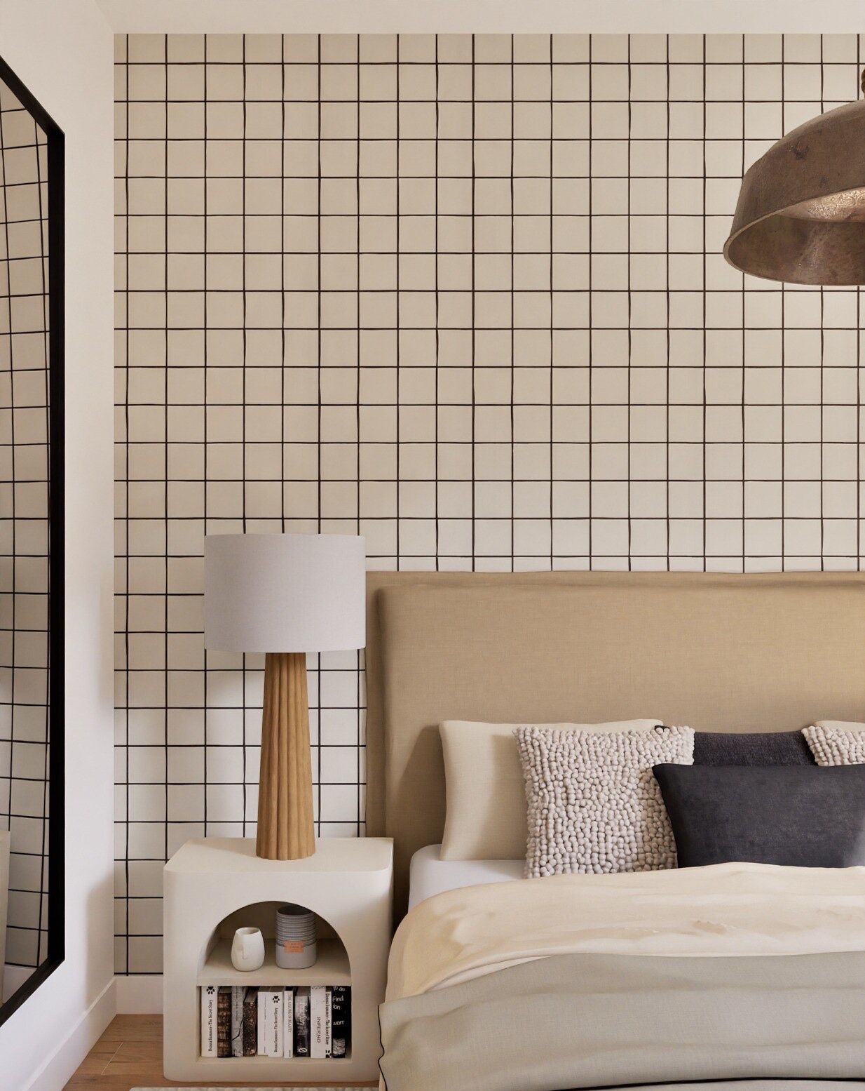 A bedroom with a grid-patterned wall, a bedside table with a lamp, a bed with pillows, and a bookshelf with books.