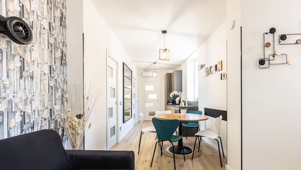 A modern kitchen with a dining area, wooden flooring, and a black sofa. - Heart Holiday in Sorrento (Sorrento)