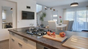 A modern kitchen with a central island, built-in appliances, and a dining area with a view.