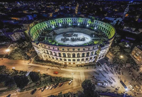 A historic amphitheater with a central open area surrounded by multiple levels of seating.